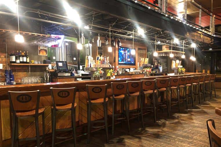 industrial looking bar area with bar stools lined up