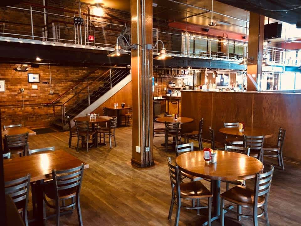 industrial looking dining room with wood floors and brick walls.