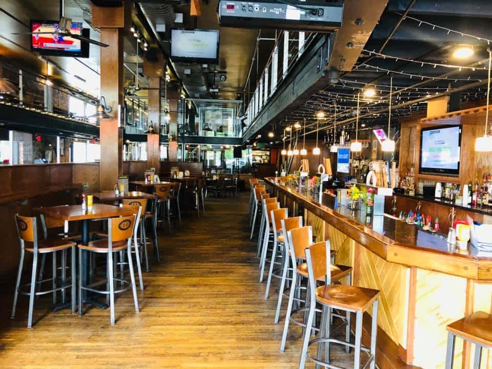 industrial looking bar area with wood floors and brick walls.